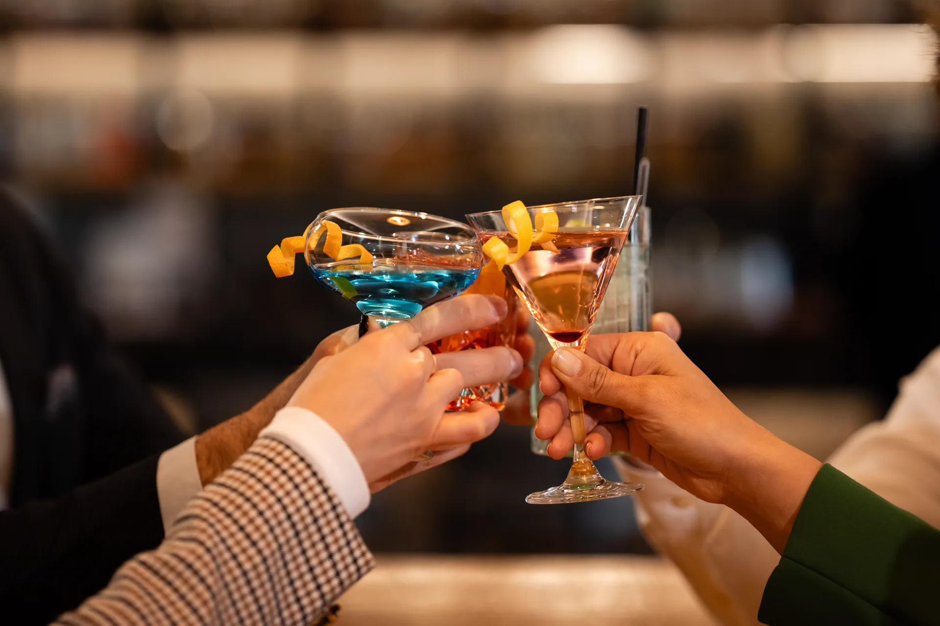Friends clinking cocktail glasses together in celebration